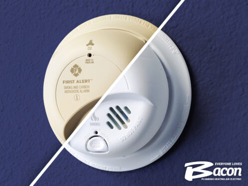 A split image shows an old, yellowing smoke and carbon monoxide detector on the left and a new, white detector on the right. The Bacon Plumbing Heating Air Electric logo appears in the bottom right corner.